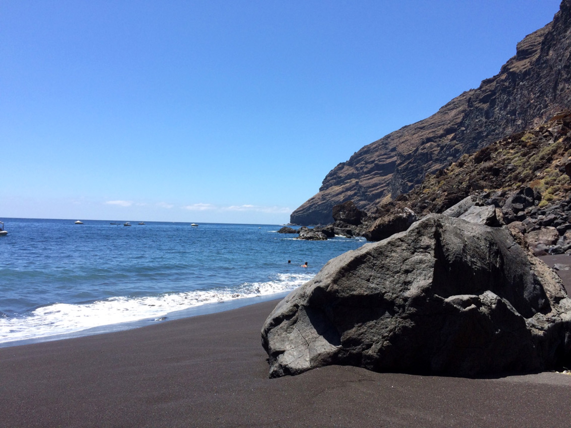 Black lava beach with swimmers near Puntagorda