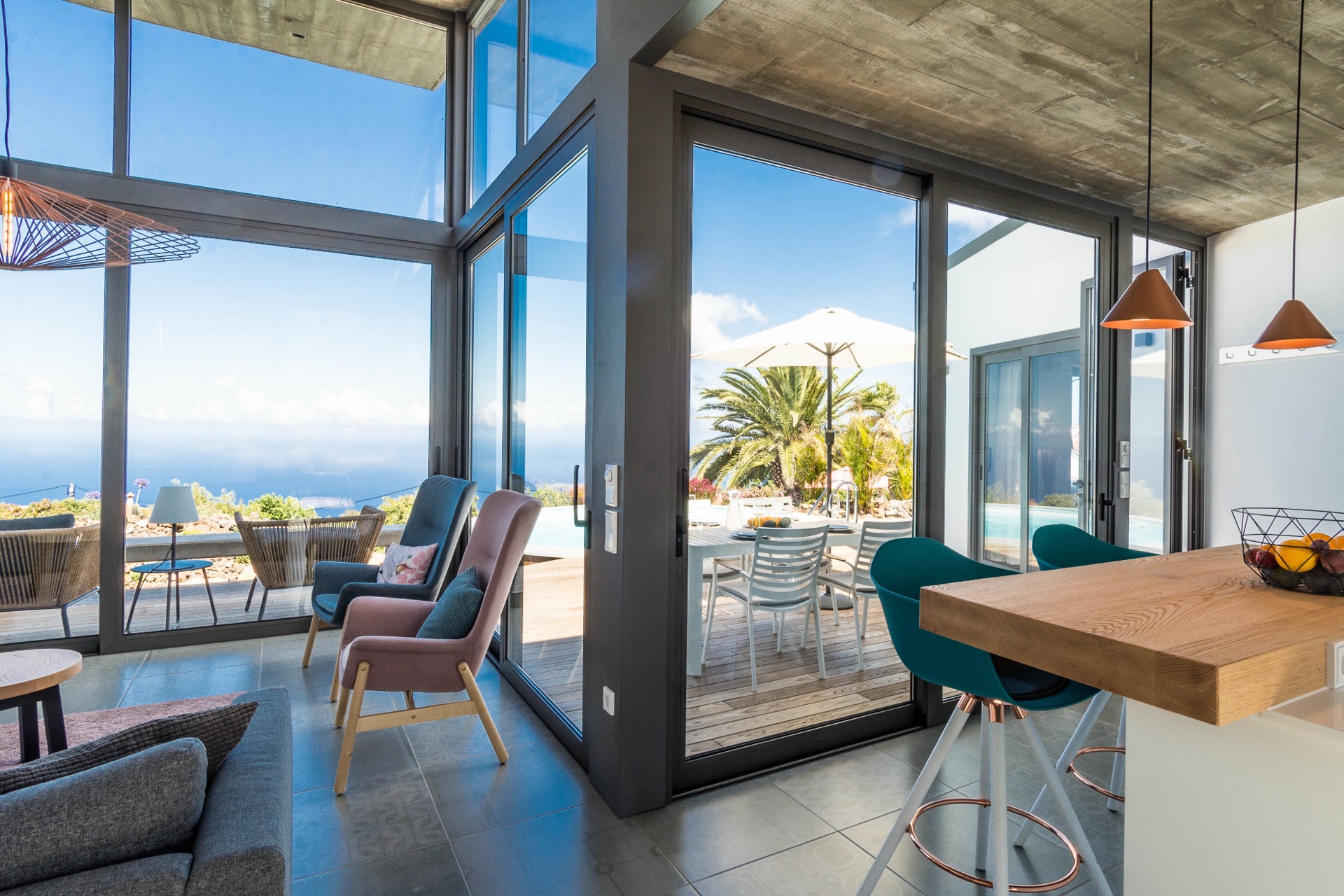 Salón de la Casa con frente de cristal, terraza y vista al mar