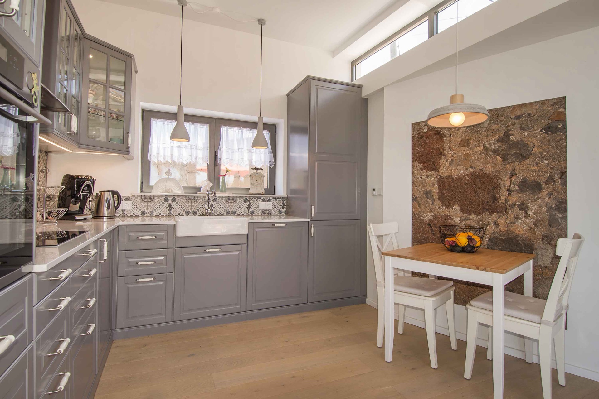 Cocina rústica gris con pared de piedra natural