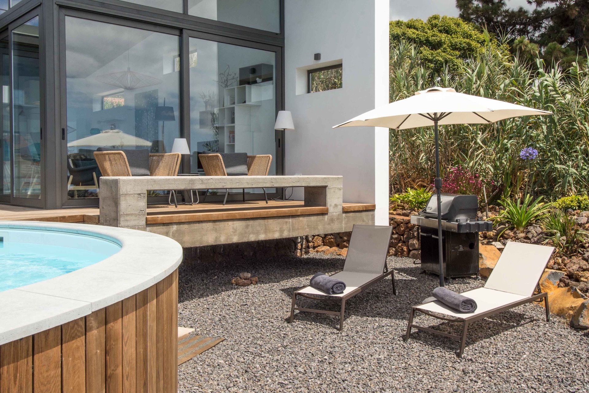 Terraza de la piscina con hamacas y parrilla